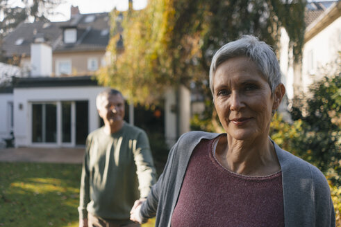 Zärtliches älteres Paar hält sich im Garten an den Händen - KNSF05561