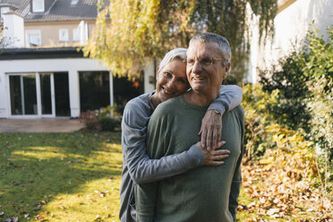 Happy affectionate senior couple hugging in garden - KNSF05563