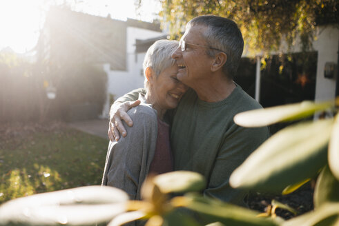 Glückliches zärtliches älteres Paar, das sich im Garten umarmt - KNSF05564