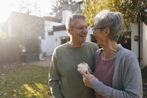 Glückliches älteres Paar mit einer Tasse Kaffee im Garten - KNSF05568