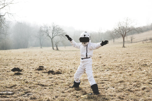 Boy wearing white space suit is posing outdoor on a meadow with virtual reality glasses - HMEF00208