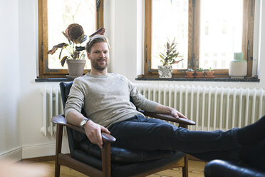 Portrait of confident casual man in stylish apartment looking into the camera - SBOF01727