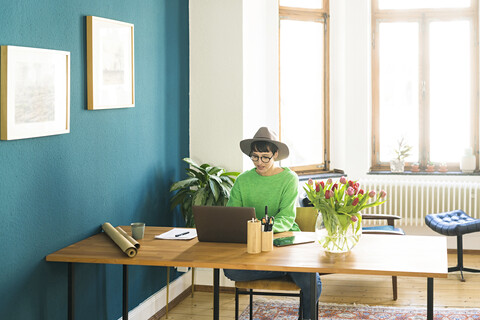 Geschäftsfrau im Heimbüro, die an ihrem Laptop arbeitet, lizenzfreies Stockfoto