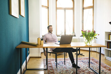 Porträt eines glücklichen, entspannten Geschäftsmannes im Heimbüro - SBOF01760