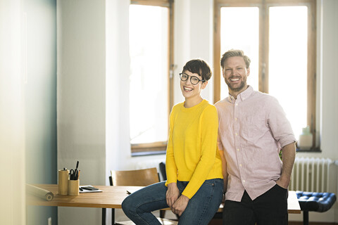 Portrait of happy couple at table in stylish apartment stock photo