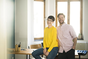 Portrait of happy couple at table in stylish apartment - SBOF01763