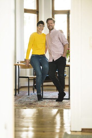 Portrait of happy couple at table in stylish apartment stock photo