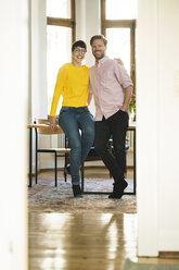 Porträt eines glücklichen Paares am Tisch in einer stilvollen Wohnung - SBOF01764