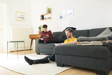 Casual couple relaxing in living room at home - SBOF01789