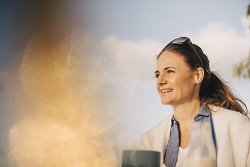 Close-up of thoughtful woman having coffee against sky - MASF11070