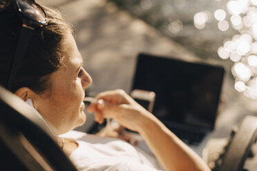 Nahaufnahme einer Frau, die im Sommer über Kopfhörer spricht - MASF11111