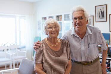 Portrait of senior couple standing arm around in nursing home - MASF11138