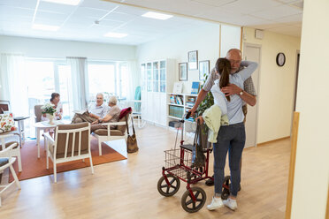 Junge Frau umarmt ihren Großvater bei einem Besuch im Pflegeheim - MASF11142