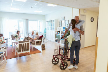 Young woman embracing grandfather during visit at nursing home - MASF11142