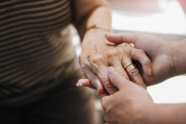 Ausgeschnittenes Bild einer Altenpflegerin, die die Hand einer älteren Frau im Pflegeheim hält - MASF11155