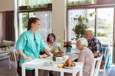Weibliche Pflegekraft serviert älteren Menschen im Pflegeheim eine Mahlzeit - MASF11162