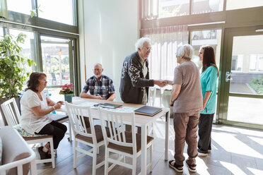 Älterer Mann und Frau schütteln sich in der Nähe von Freunden und Krankenschwester im Pflegeheim die Hände - MASF11175