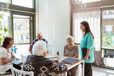 Female healthcare worker talking with elderly people at nursing home - MASF11178