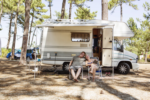 Frankreich, Gironde, glückliches Paar vor einem Wohnwagen auf dem Campingplatz, lizenzfreies Stockfoto