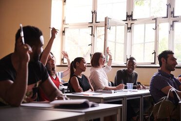 Intelligente Schüler heben die Arme, um im Klassenzimmer zu antworten - MASF11266