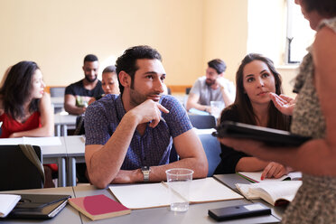 Männliche und weibliche Schüler, die den Lehrer beim Erklären im Klassenzimmer beobachten - MASF11274