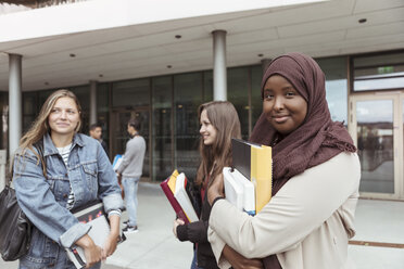 Porträt einer Studentin im Hijab, die mit Freunden auf dem Universitätscampus steht - MASF11317