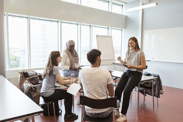 Glückliche multiethnische Studenten diskutieren im Klassenzimmer der Universität - MASF11331