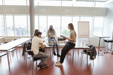 Männliche und weibliche Studenten diskutieren in einem Universitätsklassenzimmer - MASF11333