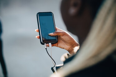 Cropped image of teenage girl listening music through smart phone - MASF11351