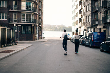 Volle Länge von Freunden Skateboarding zusammen auf der Straße in der Stadt - MASF11352