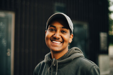 Portrait of smiling man wearing cap and hooded shirt at city - MASF11355