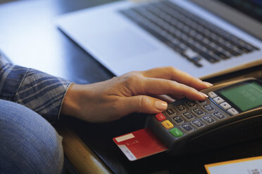 Woman with laptop using online banking, close-up - AZF00115