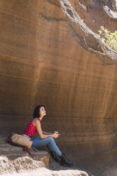 Spanien, Gran Canaria, Barranco de las Vacas, junge Frau beim Ausruhen - KKAF03109