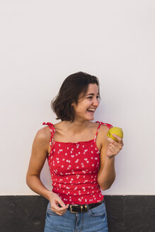 Lachende junge Frau mit Apfel - KKAF03111
