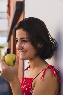 Lächelnde junge Frau mit Apfel - KKAF03112