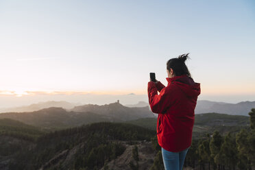 Spain, Gran Canaria, Pico de las Nieves, woman taking photo of view - KKAF03120