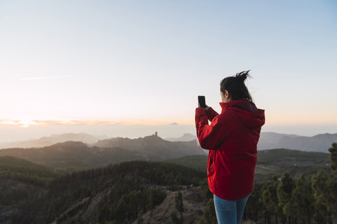 Spanien, Gran Canaria, Pico de las Nieves, Frau beim Fotografieren der Aussicht - KKAF03120