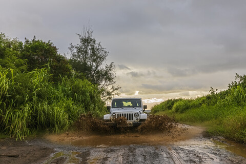 USA, Hawaii, Kauai, off-road vehicle on muddy dirt road, puddle stock photo