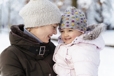 Happy affectionate mother carrying daughter in winter - DIGF05876