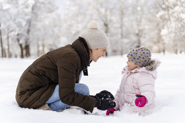 Happy mother playing with daughter in winter landscape - DIGF05882