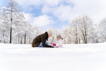 Happy mother playing with daughter in winter landscape - DIGF05884