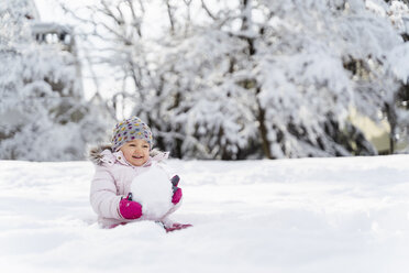 Niedliches kleines Mädchen spielt mit Schnee im Winter - DIGF05885