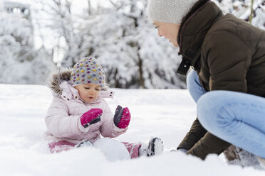 Happy mother playing with daughter in winter landscape - DIGF05886