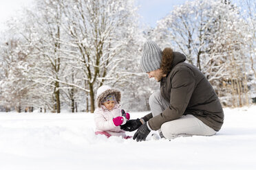 Happy father playing with daughter in winter landscape - DIGF05887