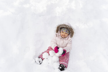 Cute little girl playing with snow in winter - DIGF05897