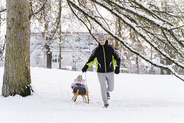 Happy father with daughter on sledge in winter landscape - DIGF05898