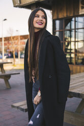 Portrait of smiling teenage girl wearing black coat - ACPF00467