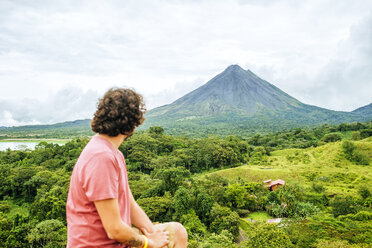 Costa Rica, Mann blickt auf den Vulkan Arenal - KIJF02325