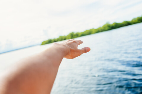 Panama, Bocas del Toro, Nahaufnahme der Hand eines Mannes auf dem Wasser, lizenzfreies Stockfoto