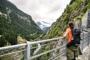 Schweiz, Wallis, Frau bei einer Wanderung von Blatten zur Riederalm auf einer Staumauer - DMOF00104